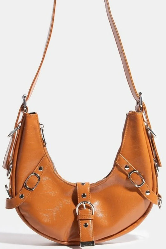 Brown leather handbag with silver buckles on a white background