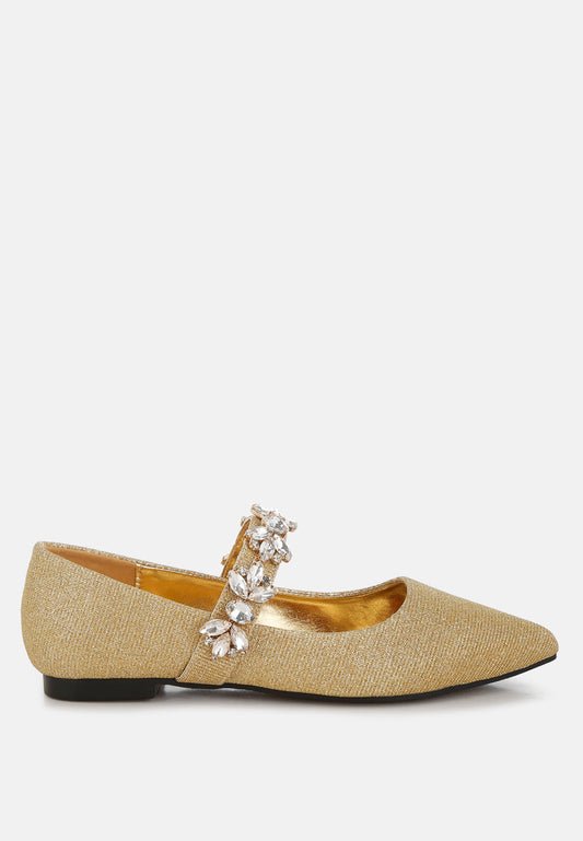Gold flat shoe with embellishments on a white background