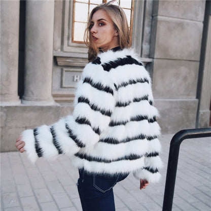 Woman wearing a black and white striped fur coat outdoors.