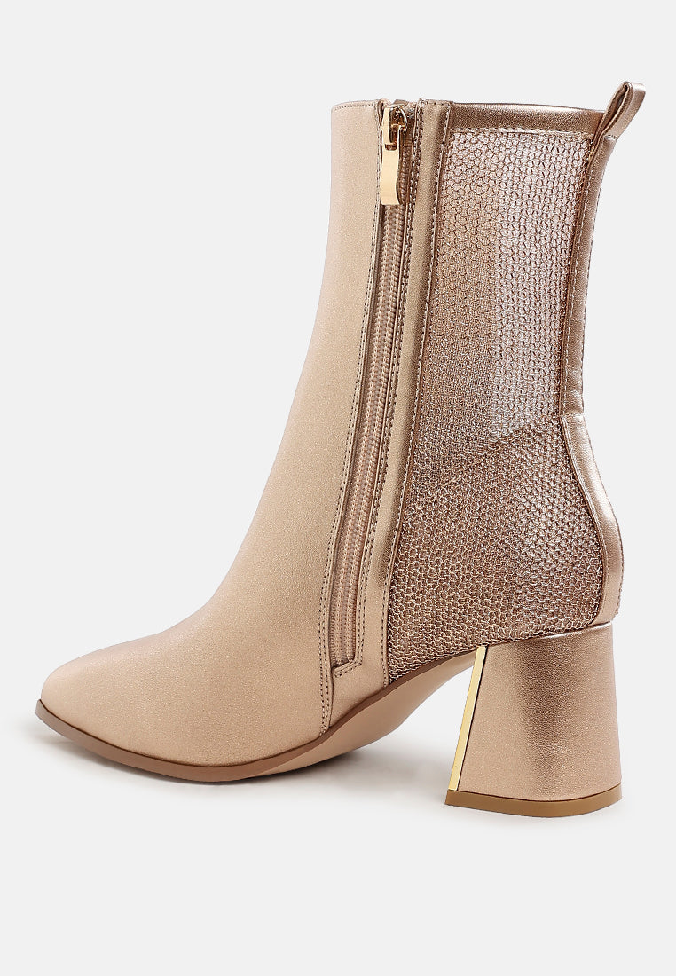 Beige ankle boot with gold zipper and heel on a white background