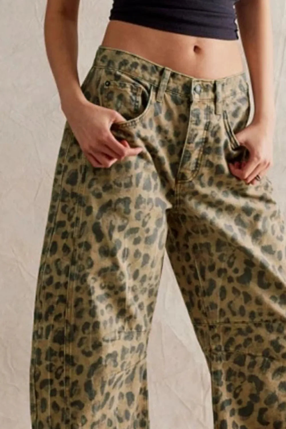 Leopard print pants worn by a person against a neutral background