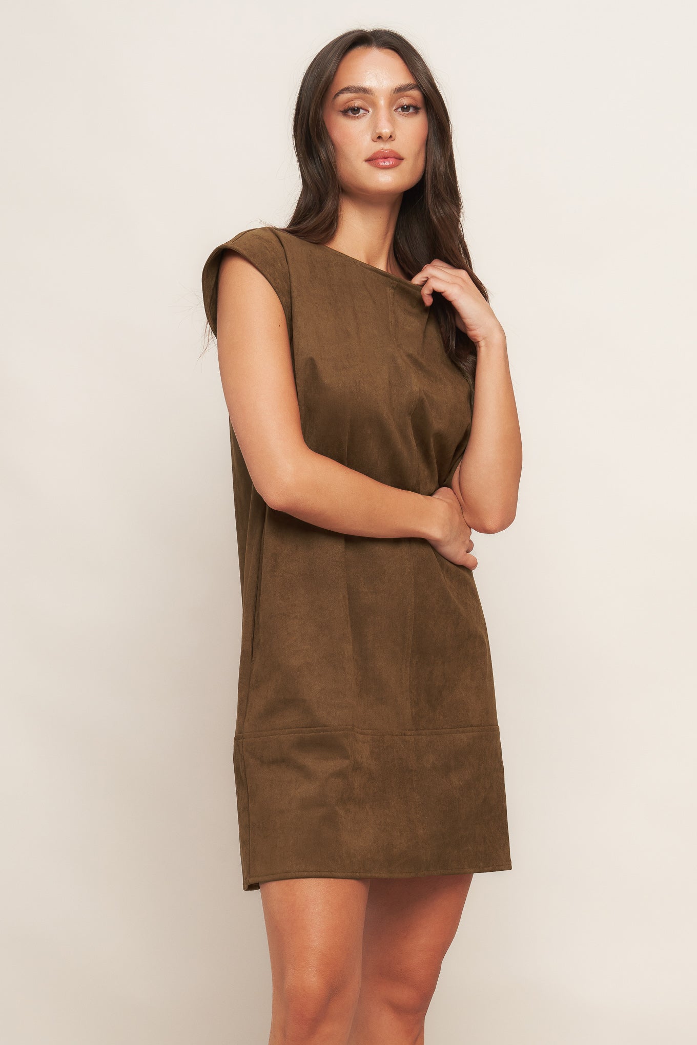 Woman wearing a brown dress against a plain background