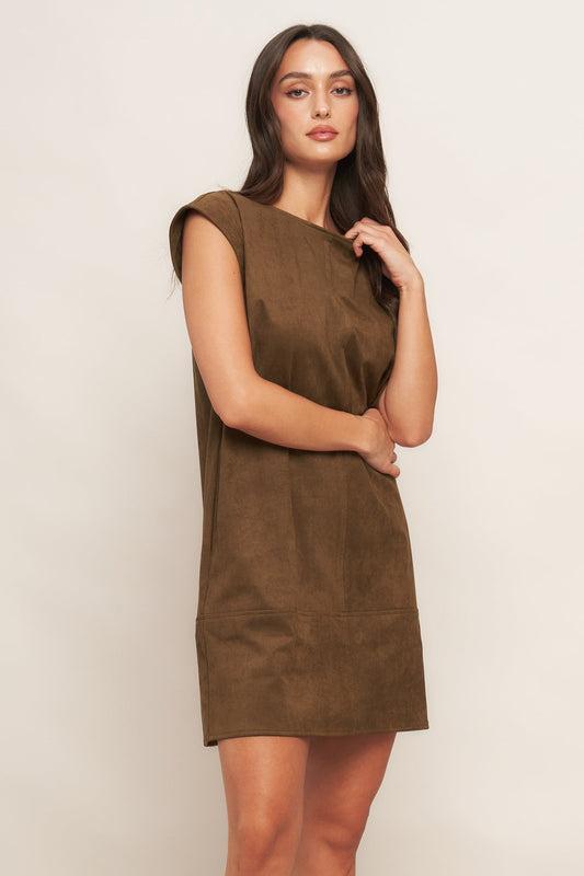 Woman wearing a brown dress against a plain background