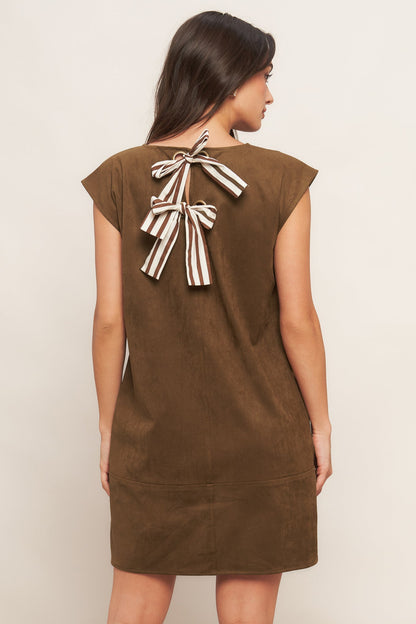 Brown dress with a bow detail on the back worn by a model against a plain background