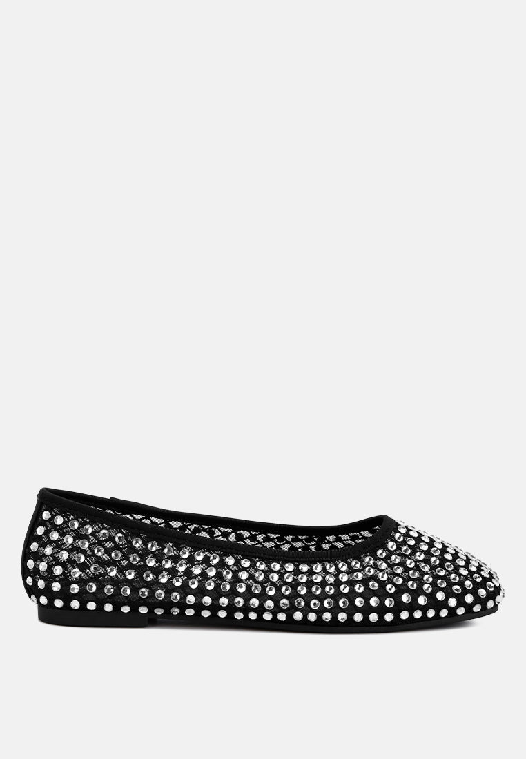 Black studded ballet flats on a white background