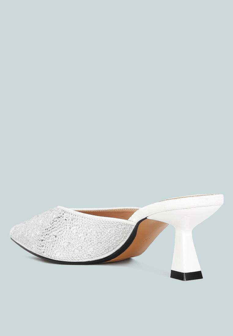 White high-heeled shoe with textured toe and black heel on a light blue background