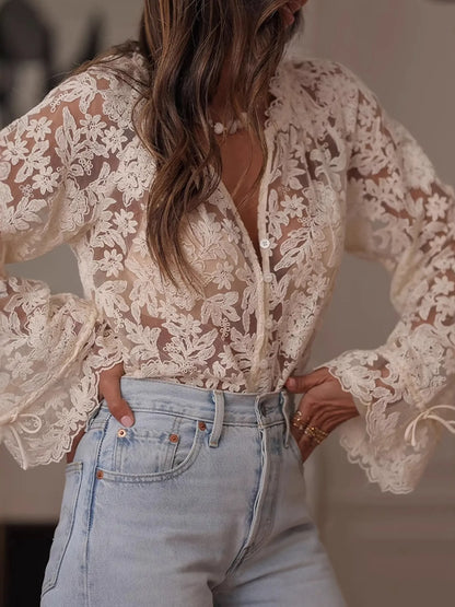 Person wearing a lace top and jeans with a blurred background