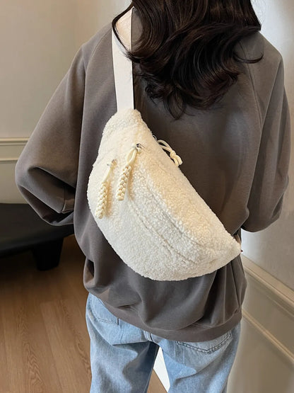 Person wearing a textured beige bag with pearl details on a neutral background