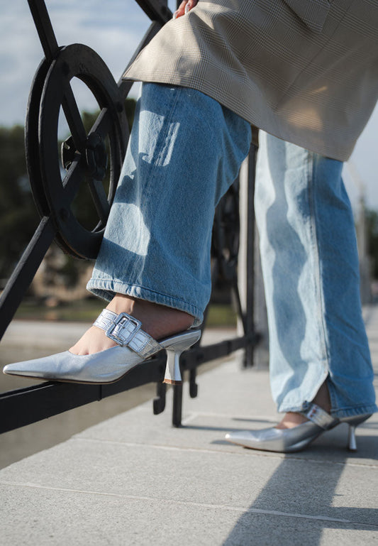 Silver slip-on mules styled with jeans