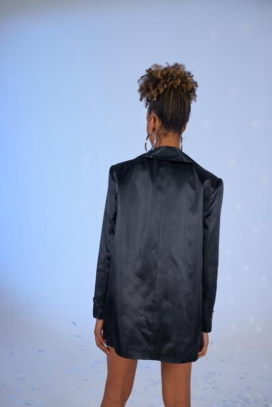 Person wearing a black leather jacket against a light blue background