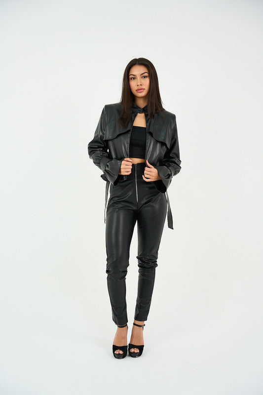 Woman wearing a black leather jacket and pants on a white background