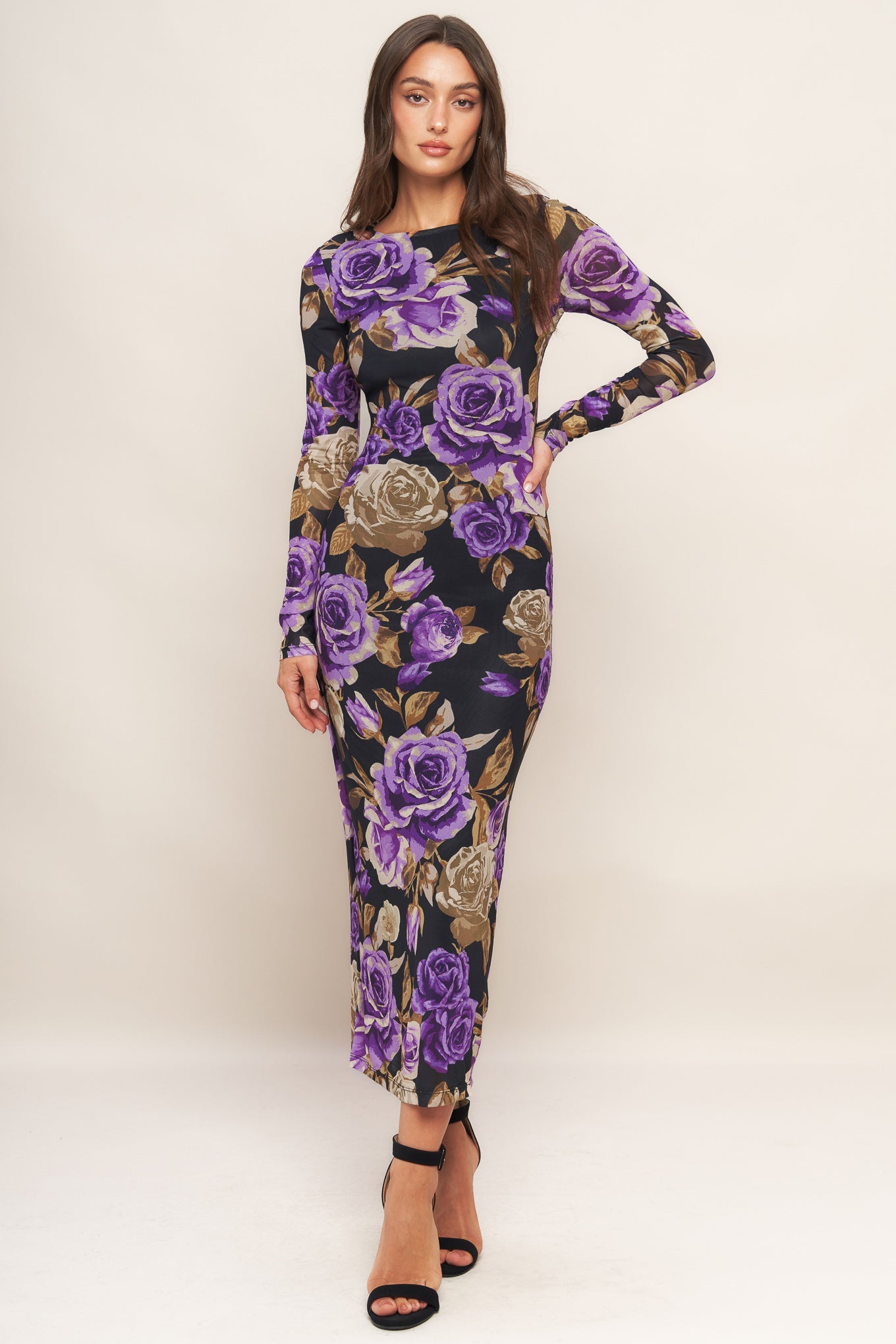Woman wearing a floral dress with purple roses on a white background