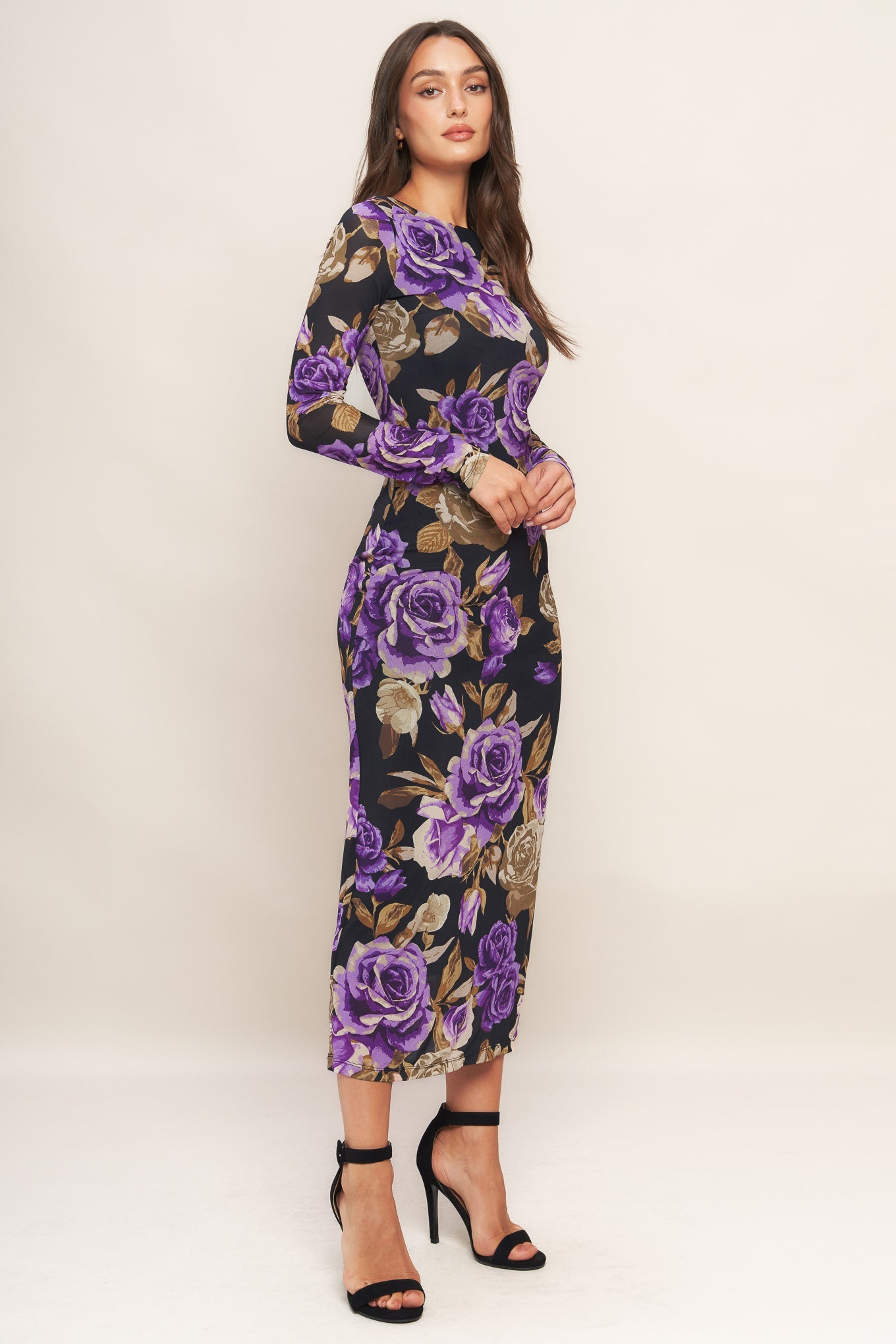 Woman wearing a floral dress with purple roses on a white background