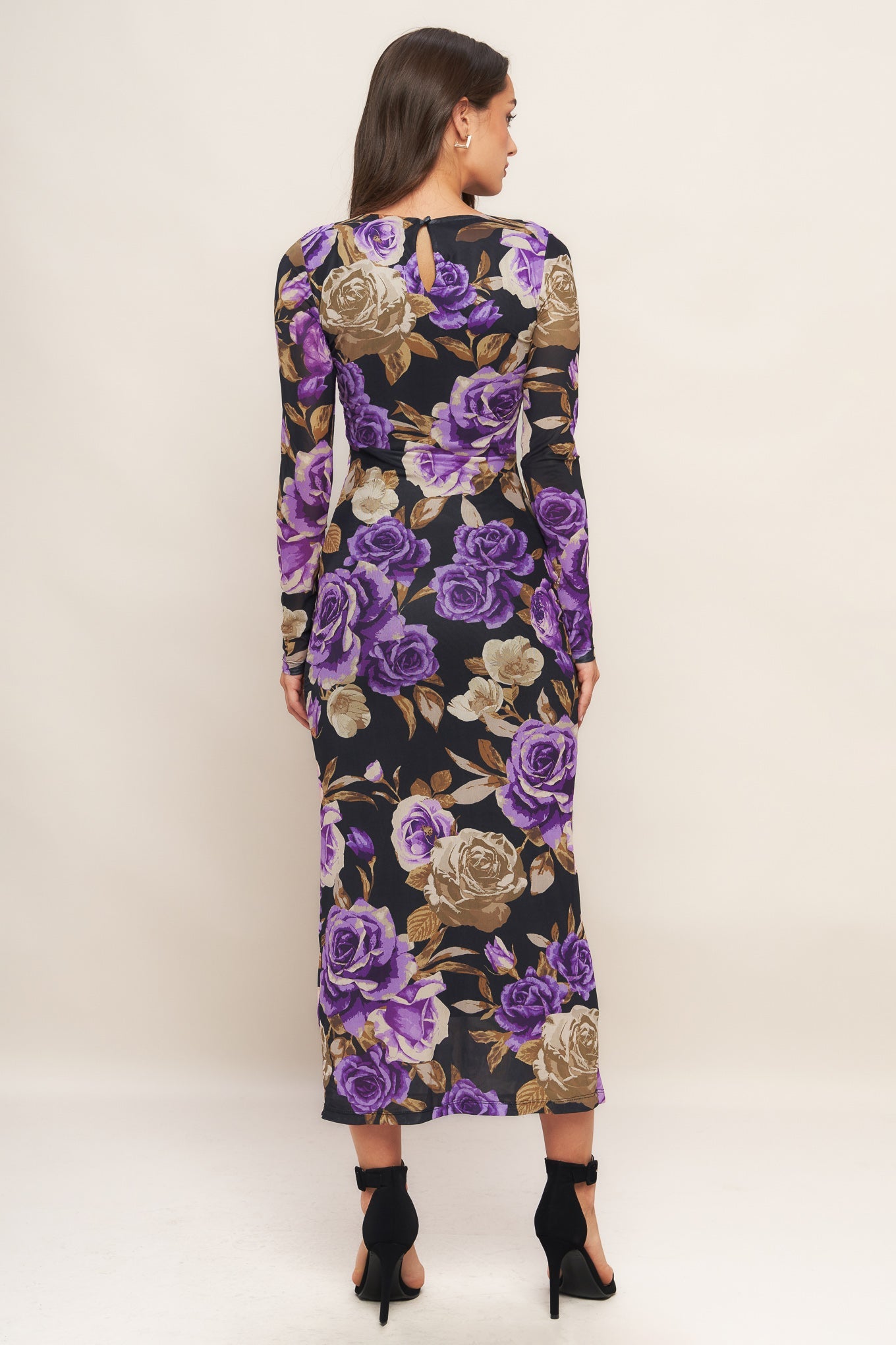 Woman wearing a floral dress with purple flowers on a white background