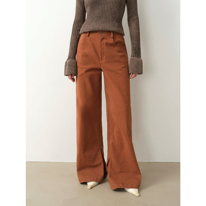 Person wearing brown ribbed sweater and wide-leg brown pants on a plain background