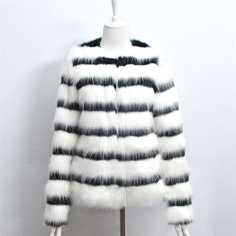 Mannequin wearing a black and white striped fur coat on a plain background