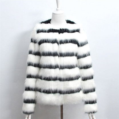 Mannequin wearing a black and white striped fur coat on a plain background