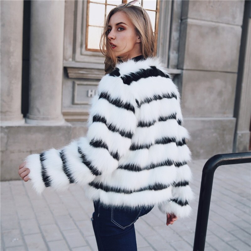 Woman wearing a black and white striped fur coat outdoors.
