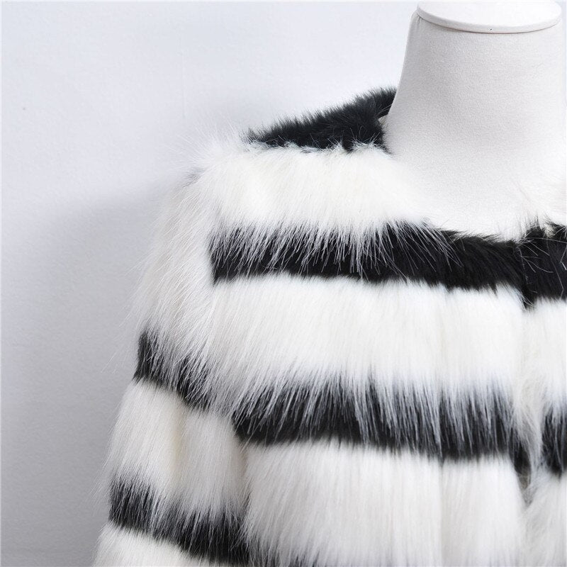 Black and white striped fur vest on a mannequin against a plain background