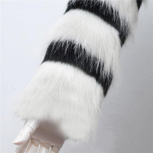 Close-up of a white paw with black stripe on a light gray background